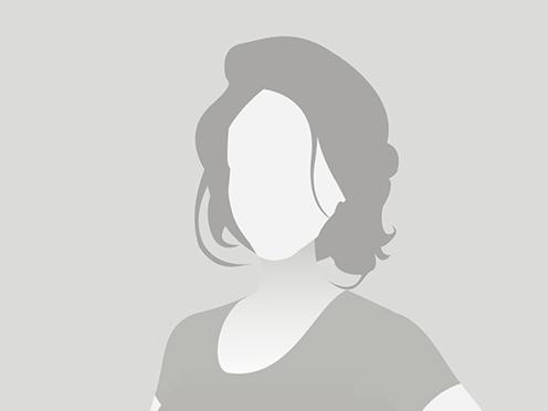 Silhouette einer Frau mit schulterlangen Haaren, die in einem schlichten Oberteil steht, vor grauem Hintergrund.