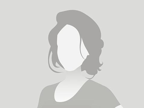 Silhouette einer Frau mit schulterlangen Haaren, die in einem schlichten Oberteil steht, vor grauem Hintergrund.